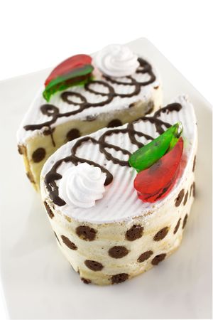 Cake vanilla-chocolate sponge with whipped cream and pieces of colored jellyの写真素材