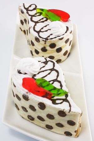 Cake vanilla-chocolate sponge with whipped cream and pieces of colored jellyの写真素材