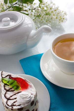 Cup of tea and sponge cake with pieces of colored jelly の写真素材