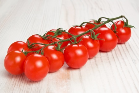 Ripe raw red Cherry tomatoes on a branch の写真素材