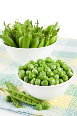 Pods green sweet organic peas in two bowl の写真素材