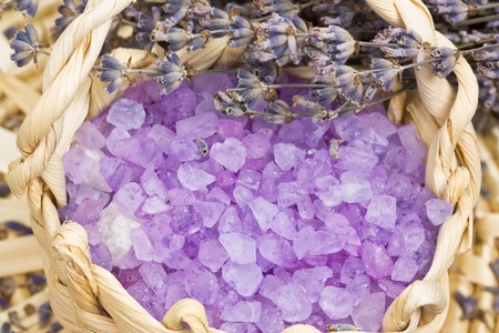 Aromatic bath salt and dry lavender flowers in wicker basket shallow DOF の写真素材