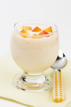 Fresh homemade yogurt with peach slices in glass bowl    の写真素材