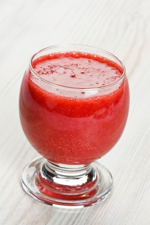 Strawberry smoothie cocktail in glass on wooden backgroundの写真素材