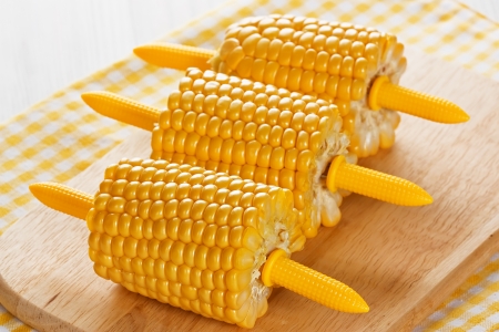 Ripe cobs of sweet corn on wooden backgroundの写真素材