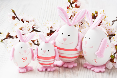 Easter rabbit egg decoration with twig of apricot flower
