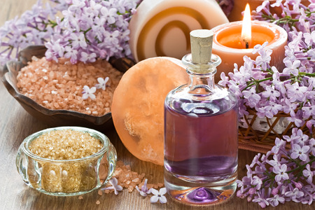 Aromatherapy essential oil, brown sugar, sea salt, natural soap and lilac flowerの写真素材