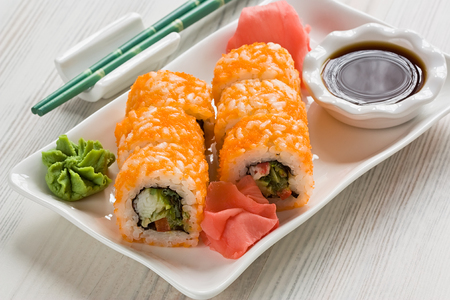 Japanese sushi with Masago, wasabi, soy sauce and ginger on white plateの写真素材