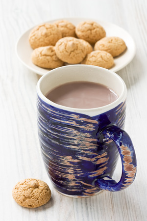 Hot cocoa drink in blue rustic mug and amaretti biscuits cookiesの写真素材