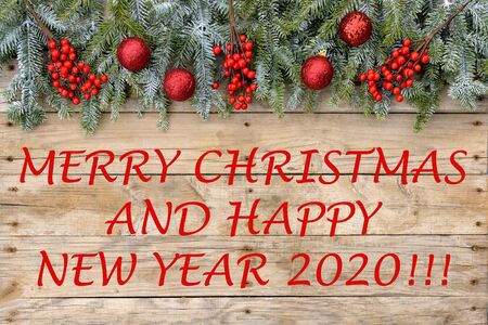 Christmas postcard frame 2020. Fir tree with red glitter balls and berries on rough wooden background. For greetings card. Xmas. Christmastime. "Merry Christmas"の写真素材