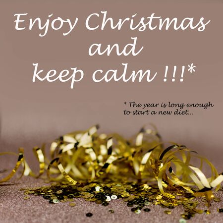 christmas greetings card. Gold glitter ribbon and sequins with text: "Enjoy Christmas and keep calm... the year is enough long to start a diet"の写真素材
