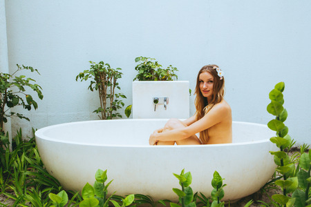 Sexy naked girl in a bath outside