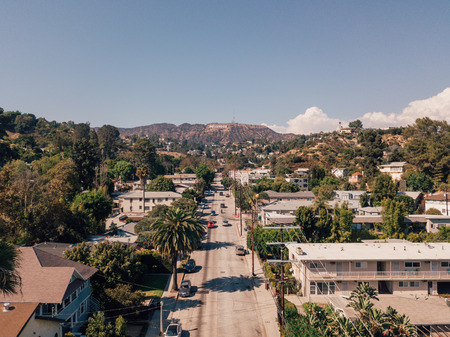 Hollywood sign district in Los Angeles, USA. Beautiful Hollywood highway road with cars, palms and a...
