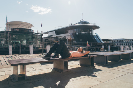 Young man chilling at the docks near Darling Harbour in Sydney, Australia. August 30, 2017.
