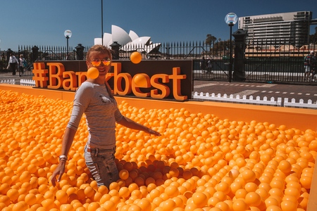Young girl playing with orange balls in the middle of the Sydney, Australia. August 30, 2017.の写真素材