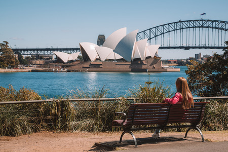Young girl having a rest in the park in Sydney by the Opera house and Harbour bridge. Australia. August 30, 2017.のeditorial素材