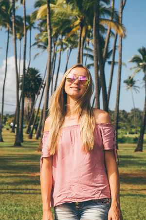 Young sexy lady standing by the palms on a paradise island. Oahu, Hawaii.の写真素材