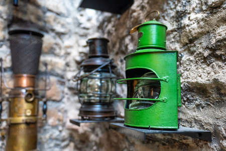 Old ship green lantern hanging on the wall.