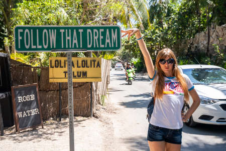 Beautiful female tourist showing motivational sign at roadsideのeditorial素材
