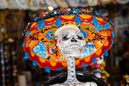 Souvenir shop with carved skeleton sculpture and colorful hatのeditorial素材