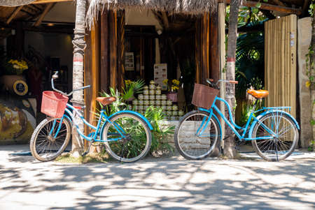 Two bicycles parked at roadside storefront with stack of jarsのeditorial素材