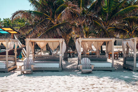 Empty beach beds with wooden chairs on sand at beautiful beach resortのeditorial素材