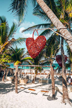 Empty swing with heart shape decor hanging on tree at beach resortのeditorial素材