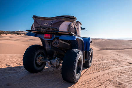 Four wheeler quadbike on sand at beach on bright sunny day