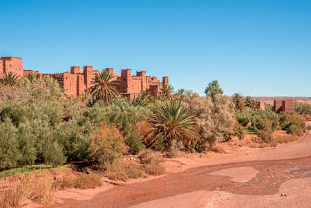 Dry riverbed and ancient fortress against clear blue sky