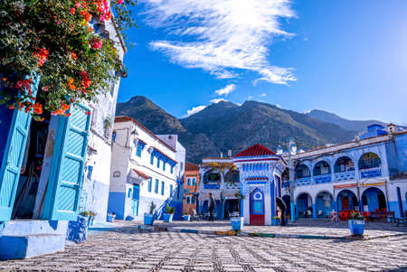 Drinking water outlet amidst cafe and residential structure, mountain in background