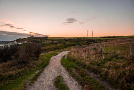 Empty country road through beautiful rural landscape during dusk