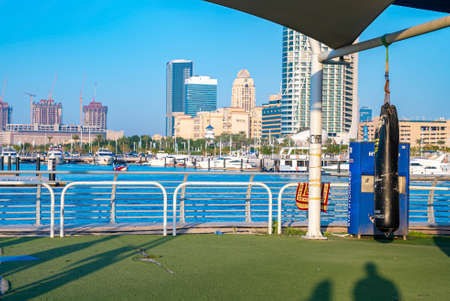 Outdoor health club in front of lake with buildings in background