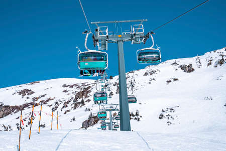 Chairlift on snowy landscape against clear sky on sunny dayの写真素材
