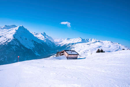 Log cabin on snow covered mountain during winter