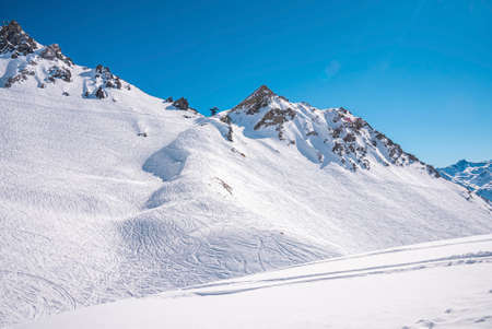 Ski tracks on snowy mountain range in alps