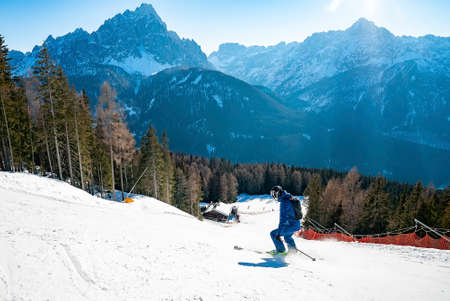 High angle view of skier skiing on slope against mountain rangeの写真素材