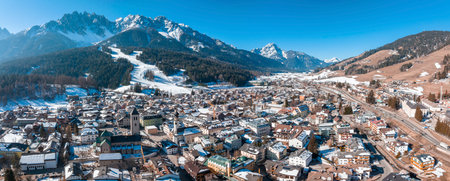 Panoramic view of buildings in town against mountains range on sunny dayの写真素材