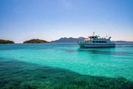 Yacht sailing on beautiful turquoise seascape against clear blue sky at island