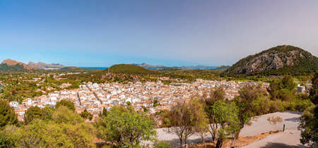 Panoramic view of townscape and mountains against clear blue sky in summer