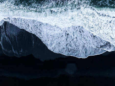 Iceland black sand beach with huge waves at Reynisfjara Vik.