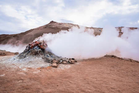 View of steam emitting from fumarole in geothermal area of Hverir against skyの写真素材