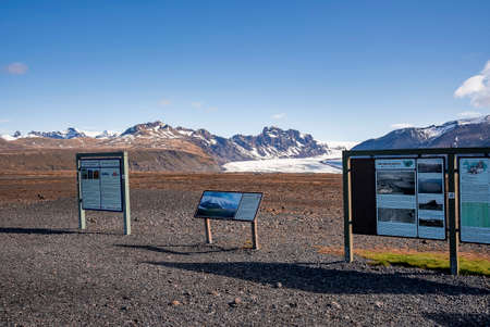 Information signboards with snowcapped mountains in background against skyの写真素材