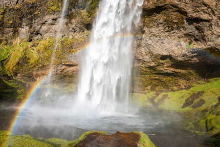 Beautiful rainbow at Seljalandsfoss flowing from mountain in river