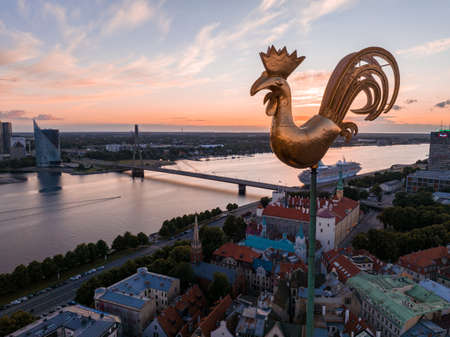 Golden cock on the top of the Dome Cathedral during sunset over Riga. Beautiful wallpaper.の写真素材