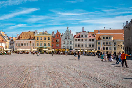Male and female tourists exploring city square in historic town against skyの写真素材