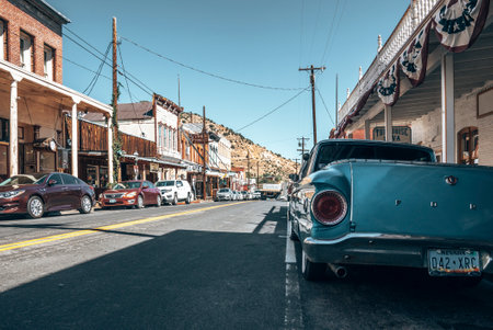 View of cars parked in row on roadside amidst old buildings at city on sunny dayの写真素材