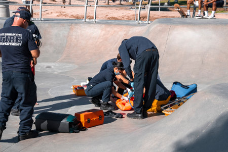 Rescue team giving treatment to injured man on skateboard ramp at park