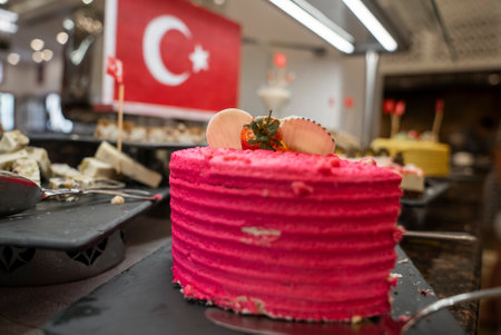 Half-eaten pink cake served on table with Turkish flag in the background