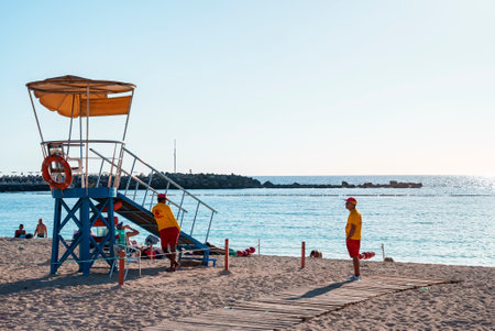 Lifeguard tower on sandy beach with clear blue sky
