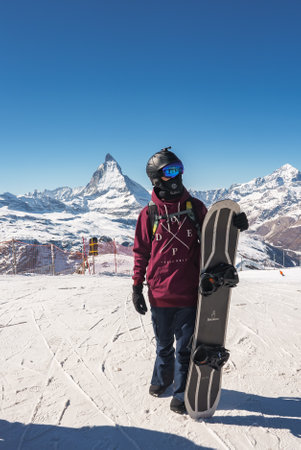 Young snowboarder spending winter holidays in Zermatt, near the famous Matterhorn peak.の写真素材